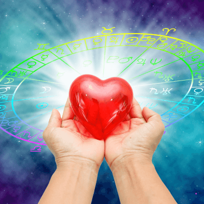 Manos sosteniendo un corazón iluminado que simboliza la compatibilidad amor signos y los vínculos conscientes en la astrología.
